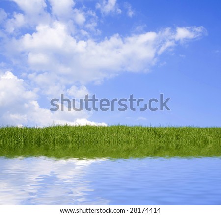 Beautiful green grass against blue sky and clouds representing perfect land.