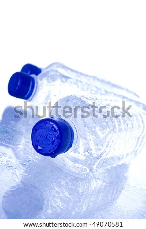 Plastic water bottles with blue cap reflecting.