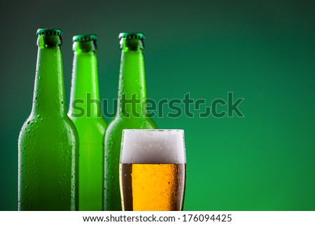 Beer bottles with glass against vivid background