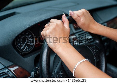 woman\'s hands holding to the wheel of a car, close up