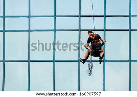 Industrial mountaineering workers wash windows of a high-rise building