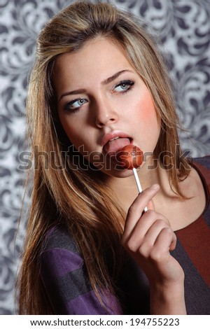 beautiful sexy girl licks red lollipop candy
