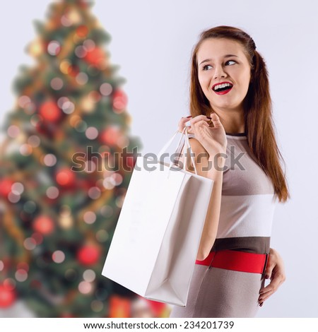 laughing brunette girl holding shopping white bag. Christmas shopping.