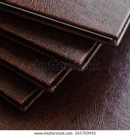 a stack of books in a brown leather hardcover, closeup