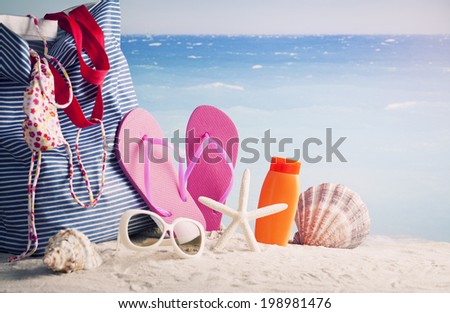 bag, sun glasses and flip flops on a tropical beac
