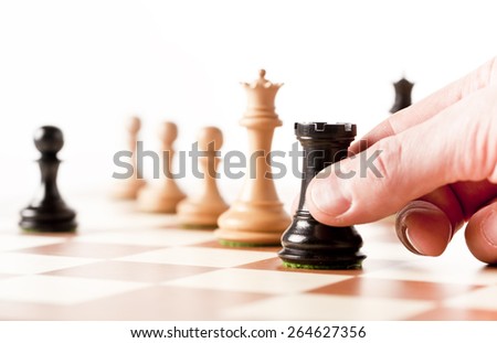 Playing chess - a hand moving black rook on a chessboard