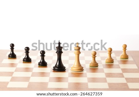 Two armies - black and white chess kings with pawns standing on a chessboard in perspective