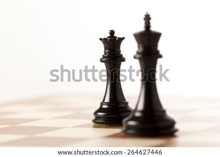 Royal pair - black chess pieces - king and queen on a chessboard