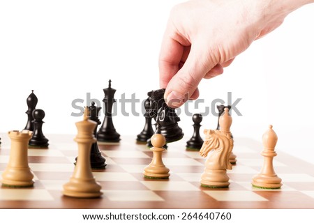 Playing the chess game - a hand moving the black knight - making strategic decisions