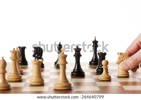 Playing chess game - a hand moving the white knight