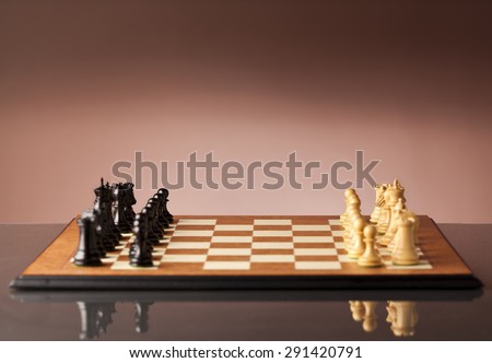 Two armies before the battle - traditional wooden chess pieces standing on a chessboard just before the game