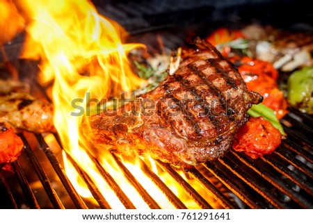 steak cooking on fire with vegetables