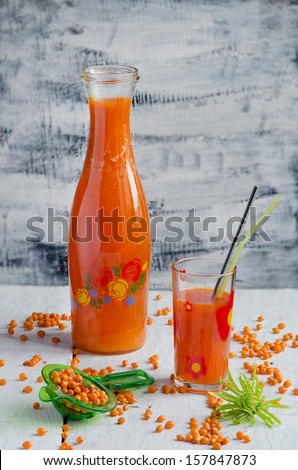 Sea buckthorn berries juice on the glass bottle