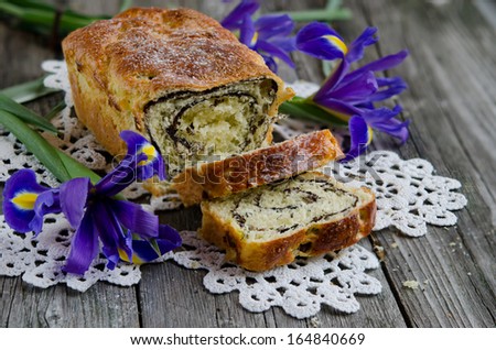 Yeast roll with cocoa and Iris flowers on the old wooden board