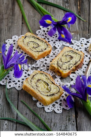 Yeast roll with cocoa and Iris flowers on the old wooden board