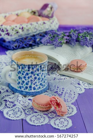 Pink macaroon, lavender flowers and cup of coffee on wooden table