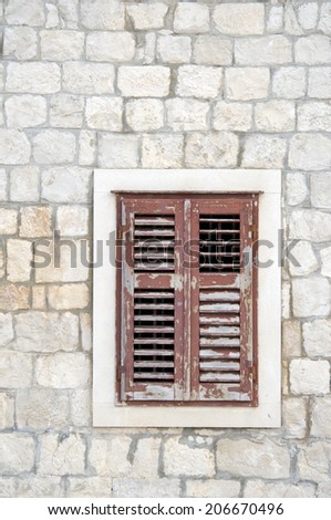 Brown window with shutters in old stone house, Croatia