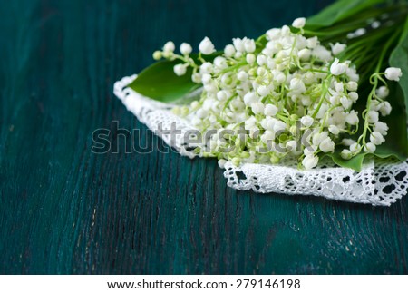 Bouquet of lilies of the valley on a blue wooden table