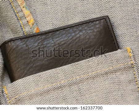 Leather purse out of denim jacket\'s hidden angled pocket