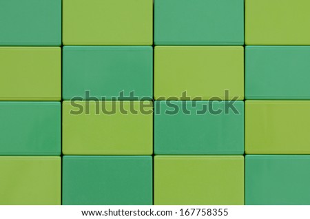 Colorful green and lime plastic block toys in checkered pattern closeup
