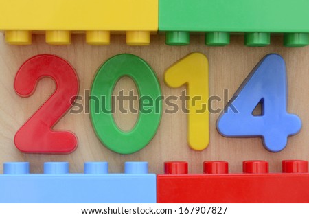 Close up of year 2014 in plastic  numbers surrounded by plastic toy blocks