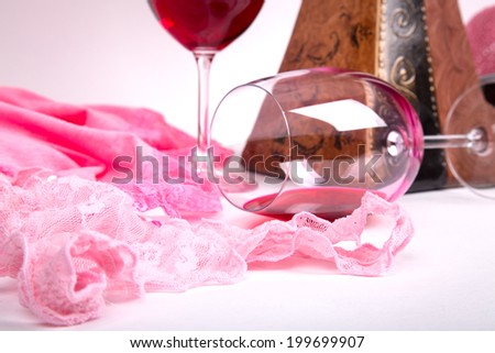 two glasses of red wine on a white background of about pink panties and t-shirts