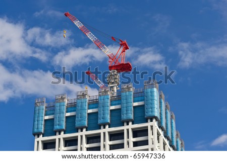 Building under construction. Safety guard rails, flyforms and tower crane