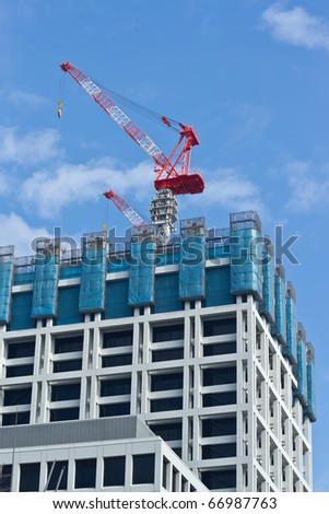 Building under construction. Safety guard rails, flyforms and tower crane