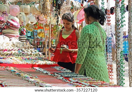 Mother and teenage daughter looking for fancy jewelry and accessories in a flea market in Goa, India