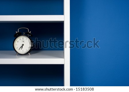 Clock inside white bookcase in blue room