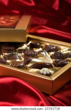 Golden chocolates box on red satin background