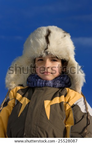 Cute little boy winter portrait in the fur-cap
