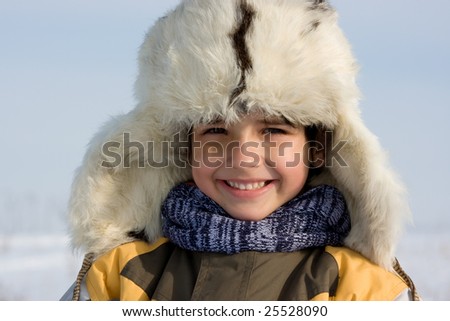 Cute little boy winter portrait in the fur-cap