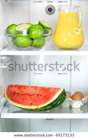 Refrigerator full with some kinds of food - fruits, juice and eggs