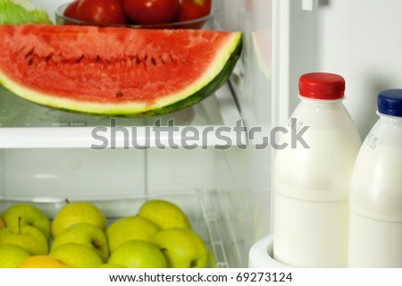 Refrigerator full with some kinds of food - fruits, vegetable and milk