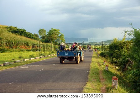 BUON ME THUOT, VIET NAM- SEPT 02: Group of farmer moving by farm tractor on country road at Vietnamese countryside, lifestyle of poor ethnic people, transport by farm truck, Vietnam, Sept 02, 2013