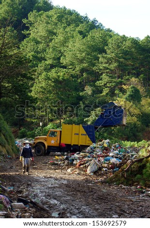 DALAT, VIET NAM- SEPTEMBER 05.Garbage truck empty out the rubbish at dumping ground. Dalat, Viet Nam- September 05, 2013