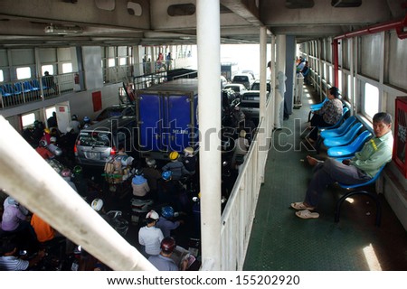 SAIGON, VIET NAM- JANUARY 20. Passenger wear helmet on motorbike at ferry boat cross the river. January 20, 2013