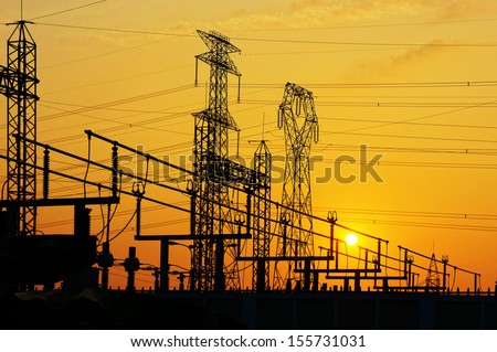 Impression network at transformer station in sunrise, high voltage up to yellow sky take with yellow tone, horizontal frame