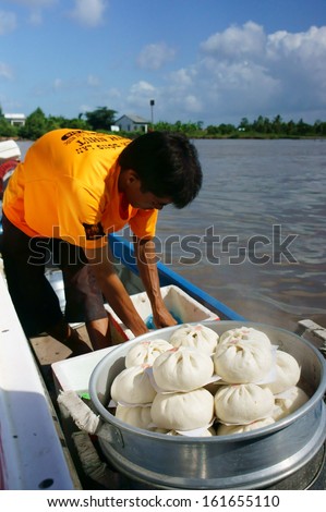 CA MAU, VIET NAM- JUNE 29: Amazing view with food vendor, he drive the motor boat  and sell dumpling on riverr, this is special culture of Mekong delta, Ca Mau, Vietnam, June 29, 2013