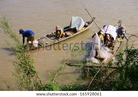 HONG NGU, VIET NAM- NOV 12: Families of fisherman do fishing on river, on the row boat, husban cast a net, his wife do fish in clean, children play alone in Hong Ngu, Viet Nam on Nov 12, 2013