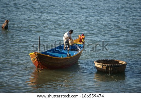 PHAN THIET, VIET NAM- FEB 3: Fisherman wash the hold of boat with water at seashore  in Phan Thiet, Viet Nam on Feb 3, 2013