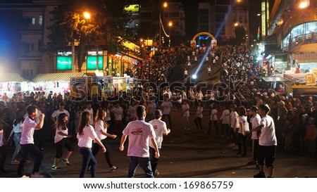 DA LAT, VIET NAM- DEC 29- Lifestyle of young people, they dance with team at outdoor night to celebrate New Year at Flower festival, large audience cheer under limelight, Dalat, Vietnam, Dec 29, 2013