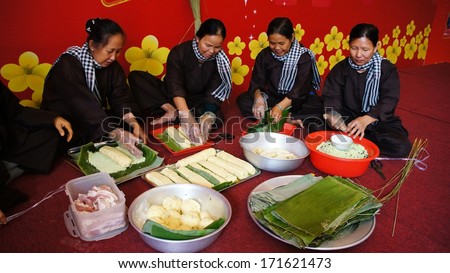 VIET NAM- JAN 15: Group of people with traditional Vietnamese dress (ao ba ba) and bandanna making traditional food- cylindric rice cake ( banh Tet) for Tet ( Lunar New Year) in Vietnam, Jan 15, 2013