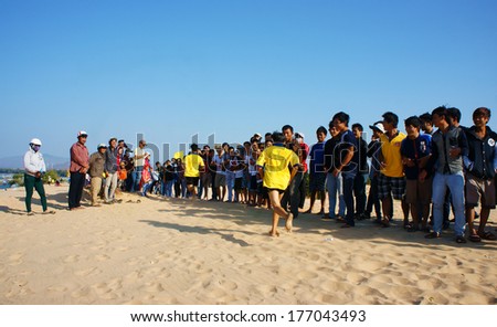 BINH THUAN, VIETNAM- FEB 14: Runners finish in marathon cross sand hill race, supporters standing in row to encourage, this public sport activity to cheer healthy lifestyle, Viet Nam, Feb 14, 2014