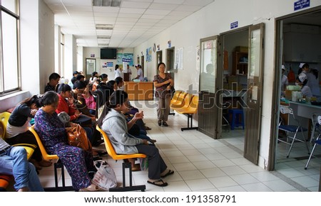 HO CHI MINH CITY, VIET NAM- APRIL 4: Crowd of people sitting and waiting to examine health, sick patient sit on bench at public hospital, Saigon, Vietnam, April 4, 2014