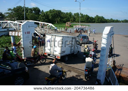 MEKONG DELTA, VIETNAM- JULY 7: Crowd of people wear helmet sitting on motorbike to cross the river by ferry boat, this is  passenger transport vehicle on water at My Loi ferry, Viet Nam, July 7, 2014