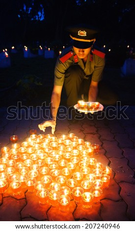 HO CHI MINH CITY , VIETNAM- JULY 26: People hold candle in July 27 event, ceremony to commenorate heroic that sacrifice in Vietnam war at martyr cemetery, Viet Nam, July 26, 2014