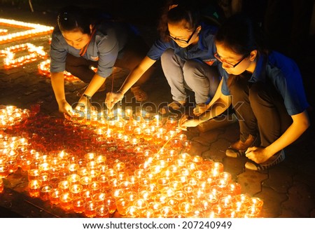 HO CHI MINH CITY , VIETNAM- JULY 26: People hold candle in July 27 event, ceremony to commenorate heroic that sacrifice in Vietnam war at martyr cemetery, Viet Nam, July 26, 2014