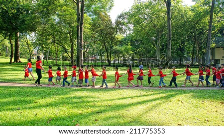 HO CHI MINH, VIETNAM- AUG 16: Extracurricular activity of preschool education, kid in team building at green park of Independence palace, unidentified chidren walk in garden, Vietnam, Aug 16, 2014
